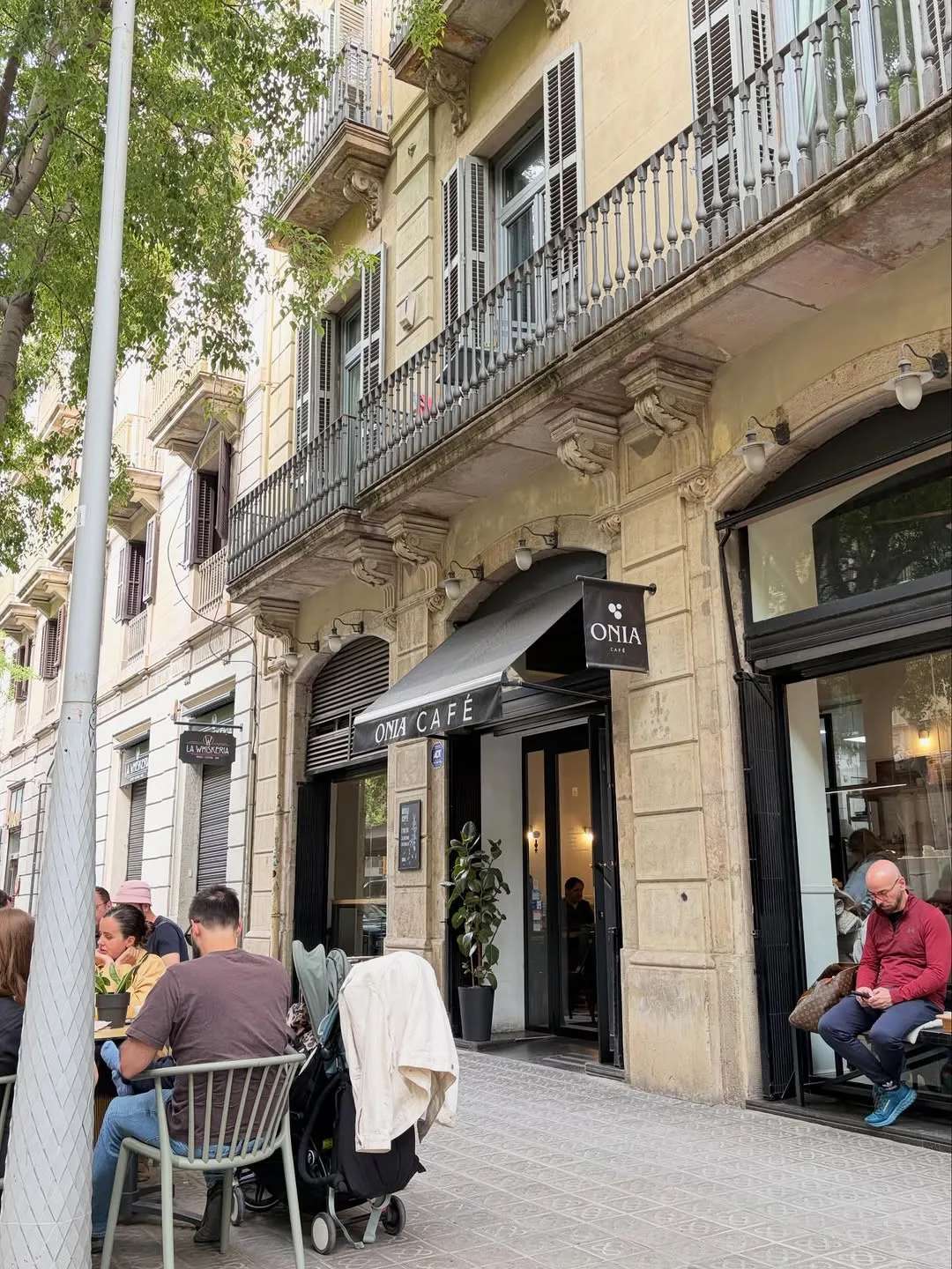 La terraza de Onia Cafè en la acera del carrer de Casp, con gente en las mesas