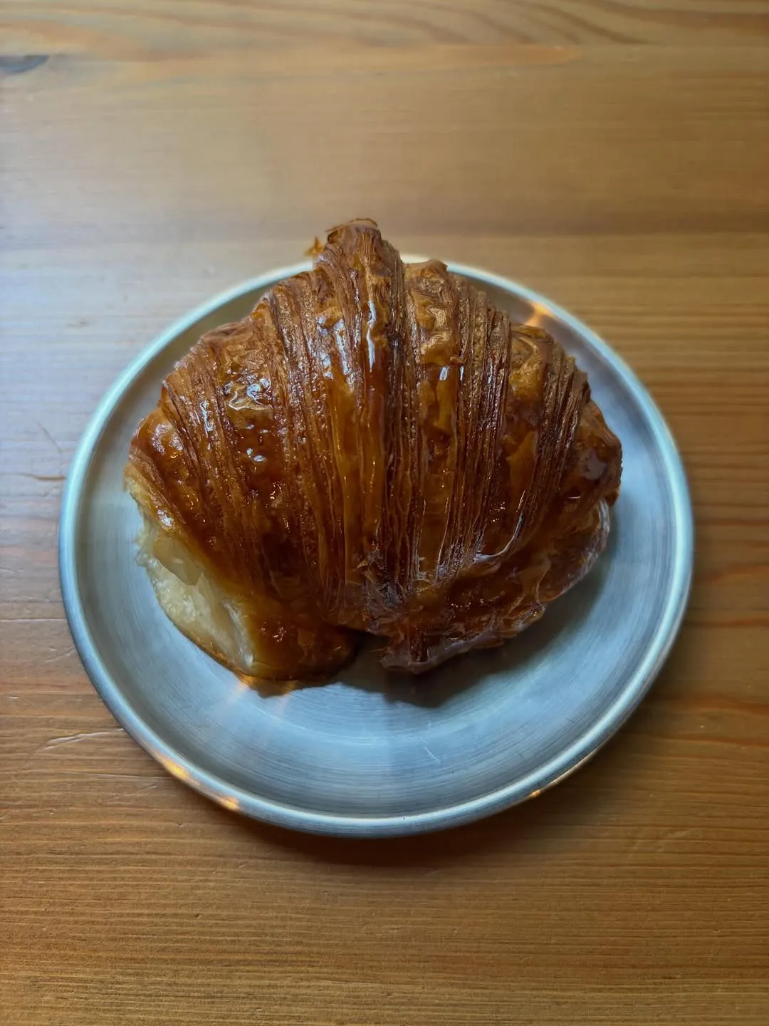 Medialuna en un plato de metal sobre una mesa de madera