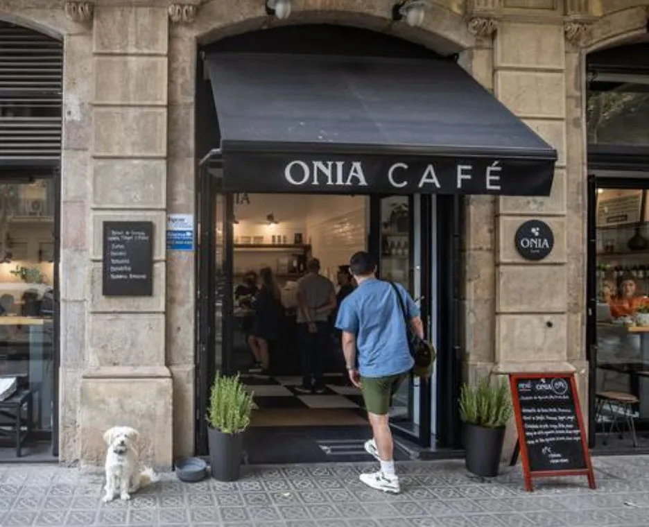 La entrada de Onia Cafè con un perro blanco en la puerta